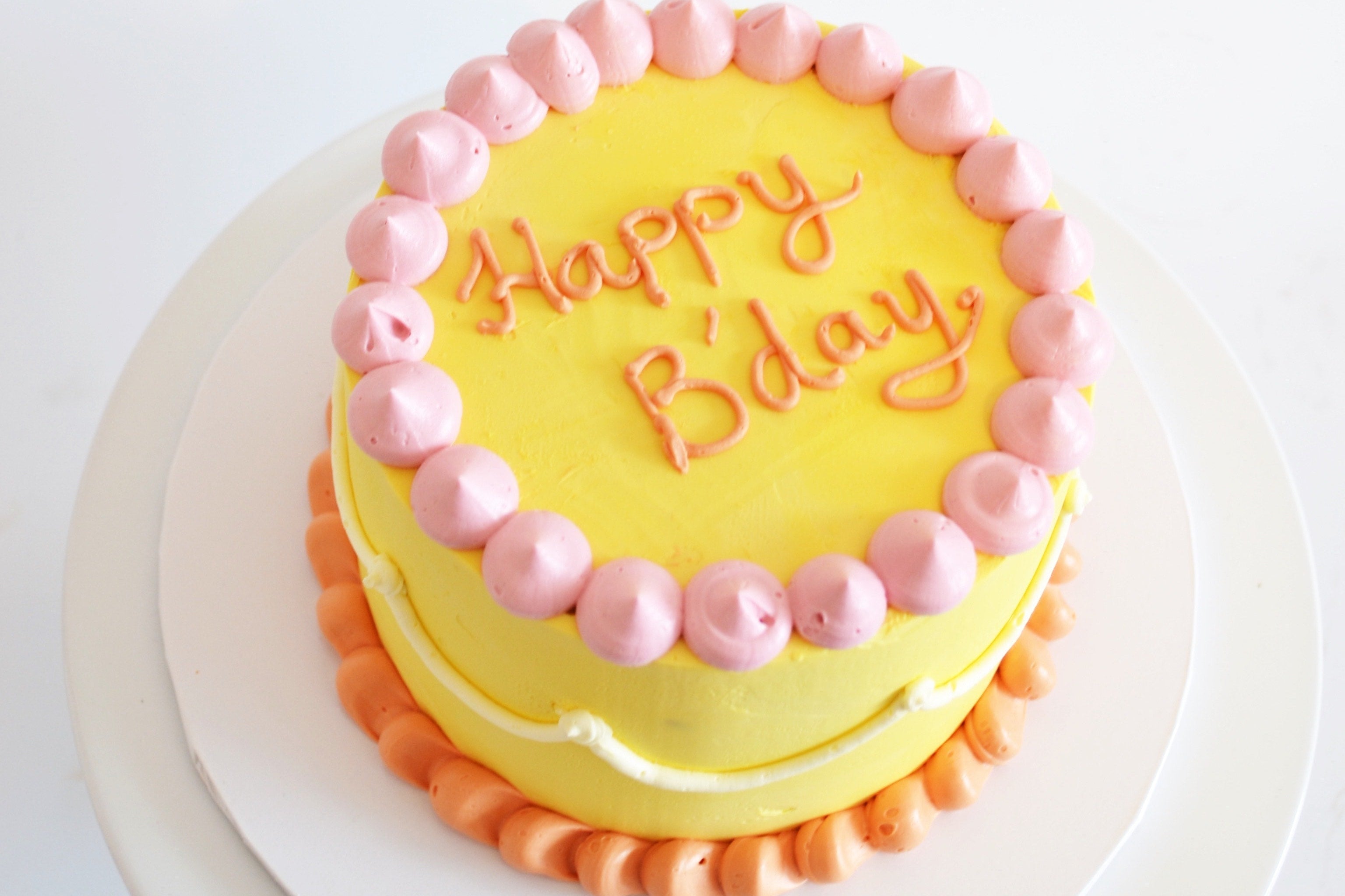 Birthday cake with pink and orange decorations on a white background